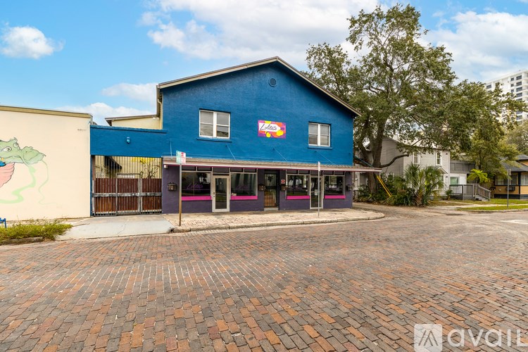 A blue building with a mural of a dinosaur on the side.