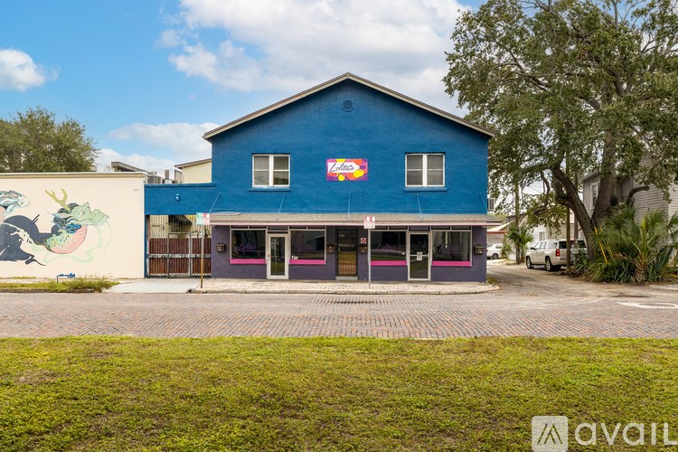 A blue building with a mural on the side of a white building.