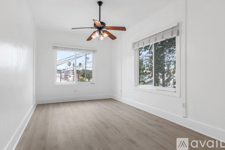 A room with a ceiling fan and a window with a view of the outside.
