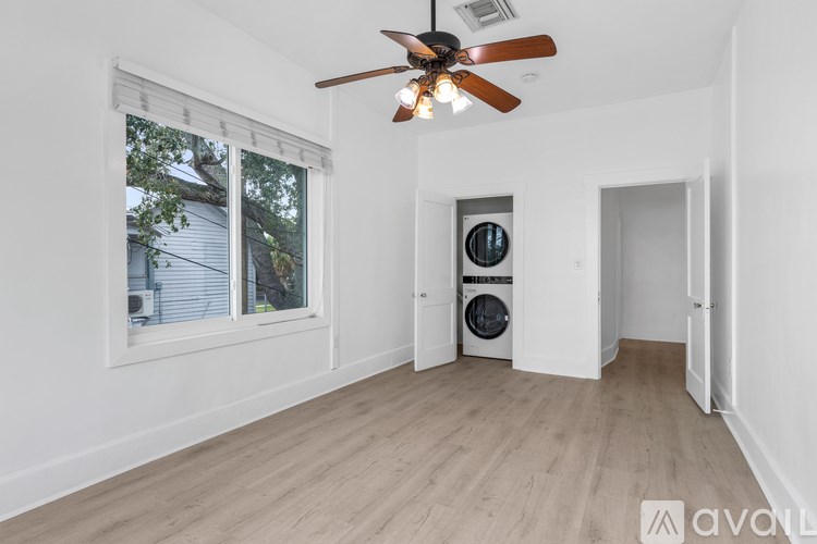 A room with a washing machine and a fan.