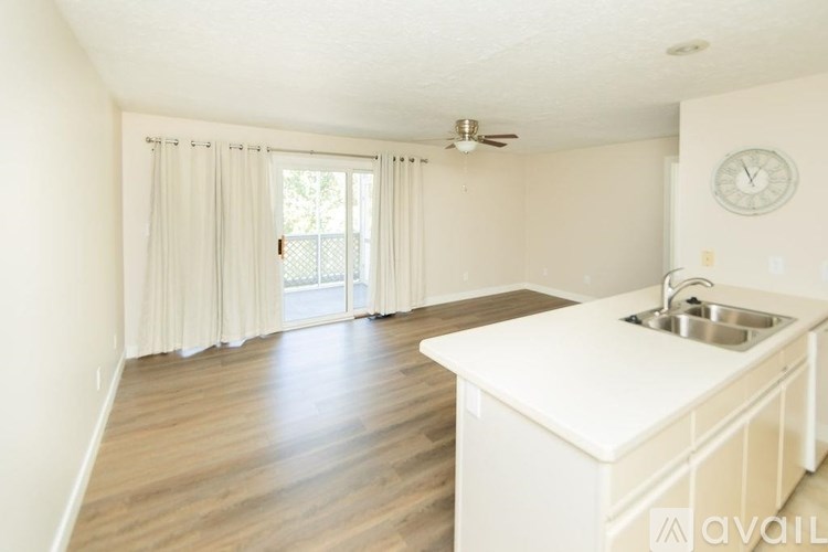 A kitchen with a white countertop and a ceiling fan.