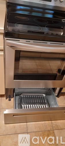 A stainless steel oven with a digital display and a drawer underneath it.