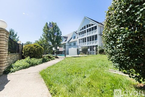 A white building with a green lawn in front.