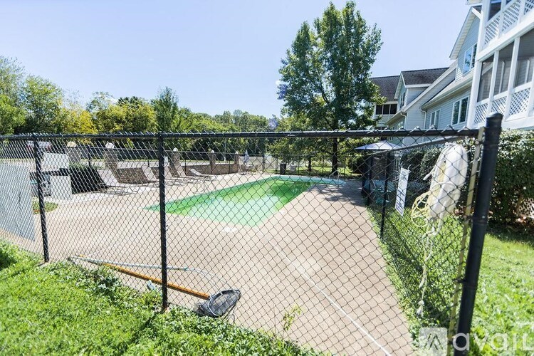 A backyard with a fence and a green lawn.