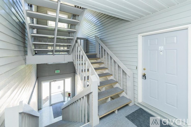 A spiral staircase in a house with a white door.