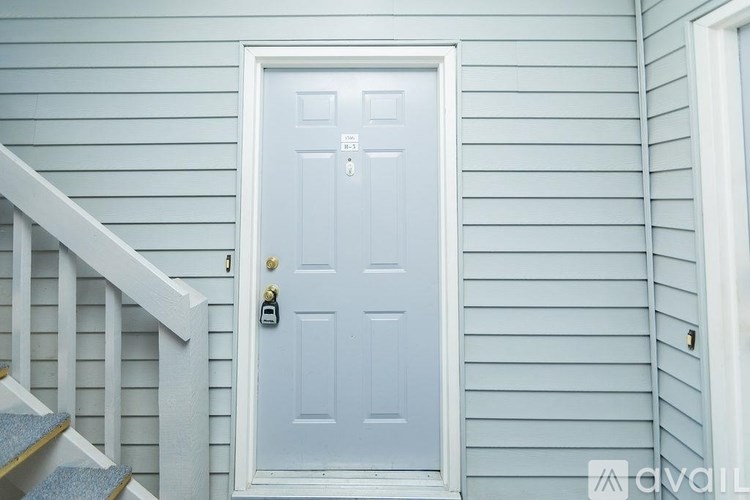 A white door with a keypad lock is set in a blue wall.