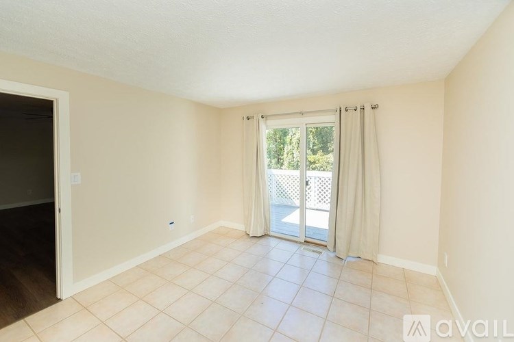 A room with a sliding glass door leading to a balcony.