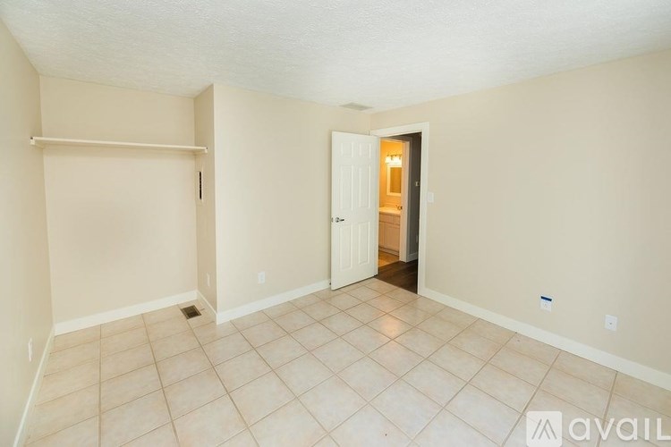 A room with a door and a wall with a shelf.