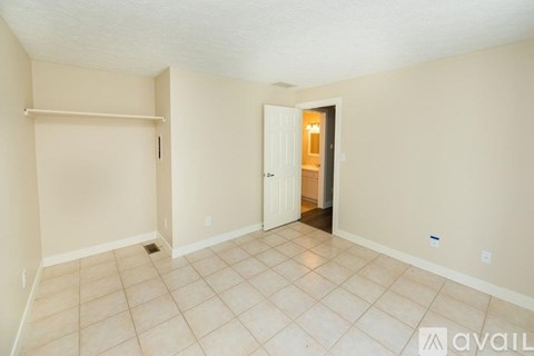 A room with a door and a wall with a shelf.