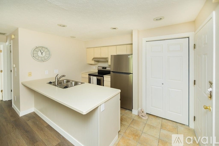 A kitchen with a sink and a refrigerator.