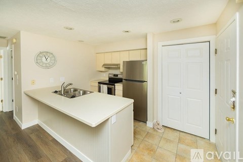 A kitchen with a sink and a refrigerator.