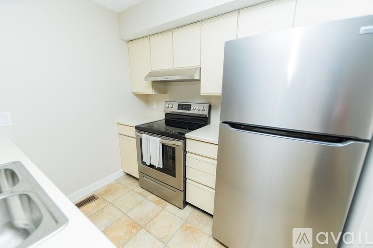 A kitchen with a stainless steel refrigerator, oven, and sink.