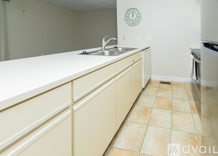 A kitchen with a sink and a clock on the wall.