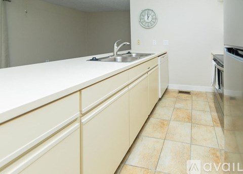 A kitchen with a sink and a clock on the wall.