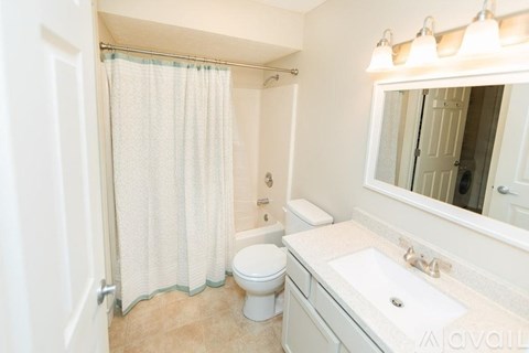 A bathroom with a toilet, sink, and shower.