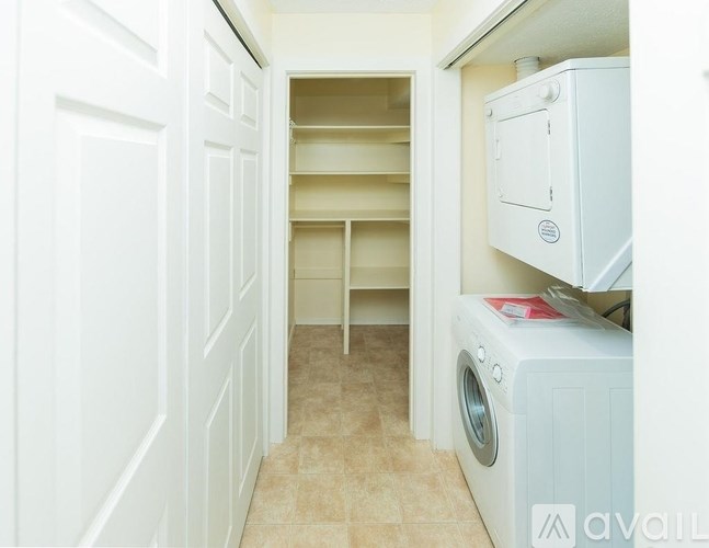 A white washing machine is in a small laundry room.
