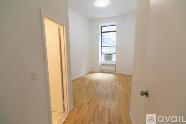 A room with wooden floors and a window.