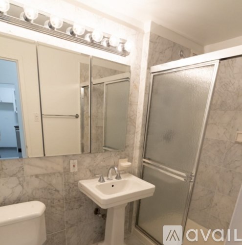 A bathroom with a white sink and a shower.