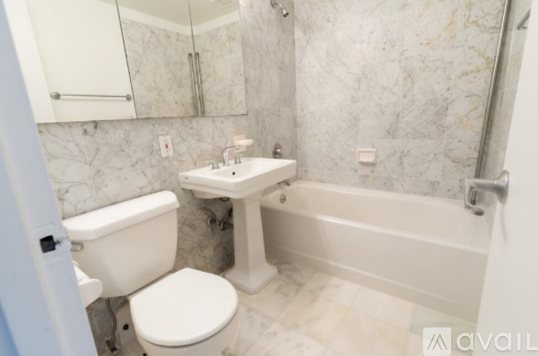 A bathroom with a toilet, sink, and bathtub.