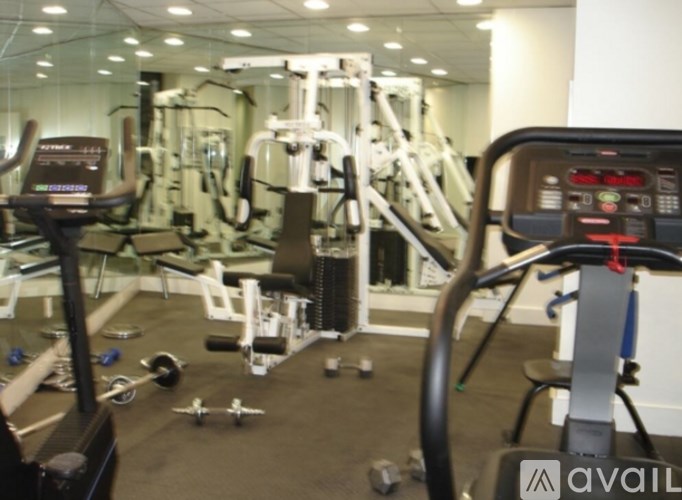 A gym with a variety of equipment including treadmills, weights, and exercise machines.
