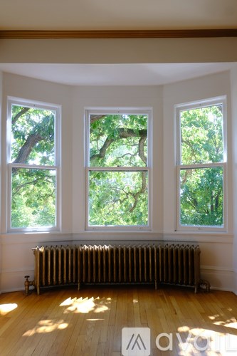 A room with a radiator and three windows.