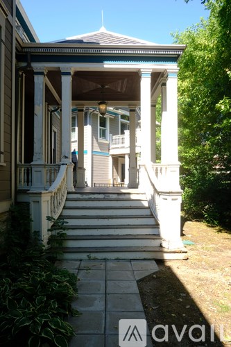 A white porch with a black roof and pillars.