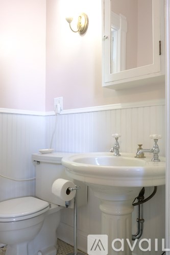 A white toilet and sink in a bathroom.
