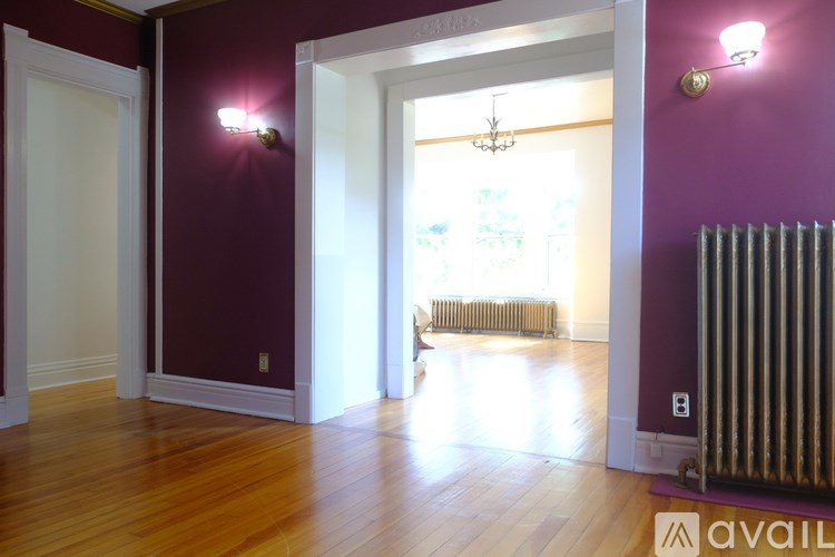 A room with purple walls and a wooden floor.