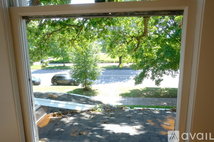 A room with a wooden floor and a white door with a cabinet underneath it.