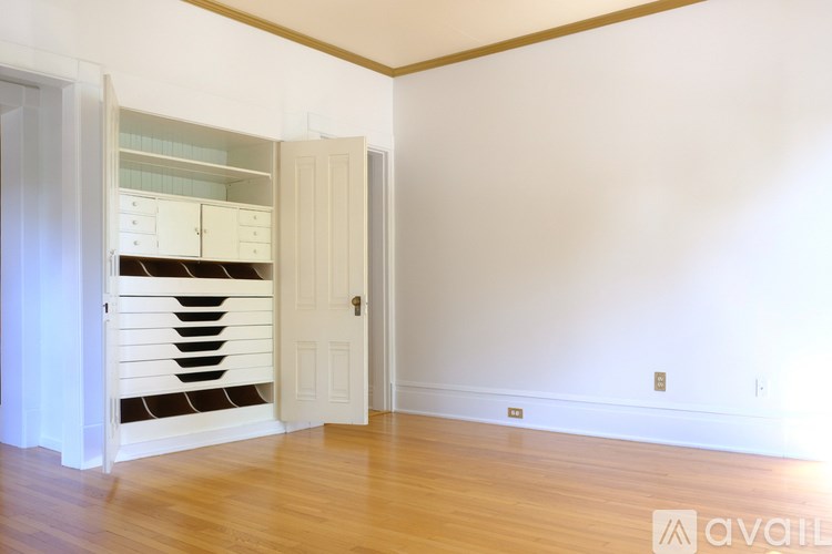 A room with a white door and a wooden floor.