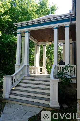 A porch with a white railing and pillars.