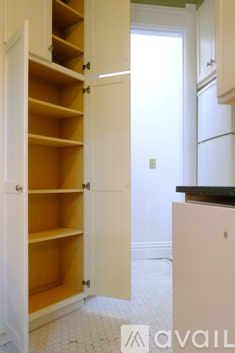 A kitchen with a white cabinet and a black counter.