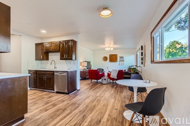 A kitchen with a white counter top and a wooden floor.