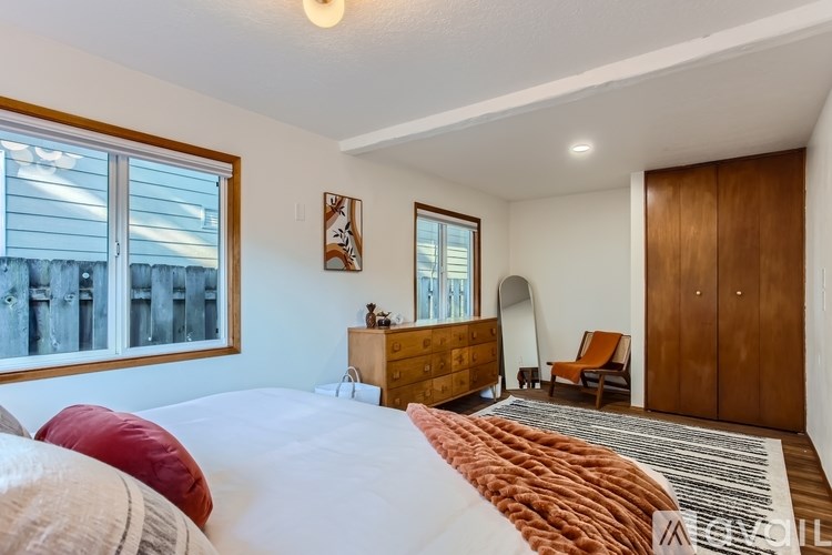 A bedroom with a large bed and a wooden dresser.