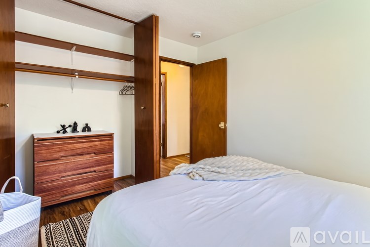 A bedroom with a bed, dresser, and mirror.