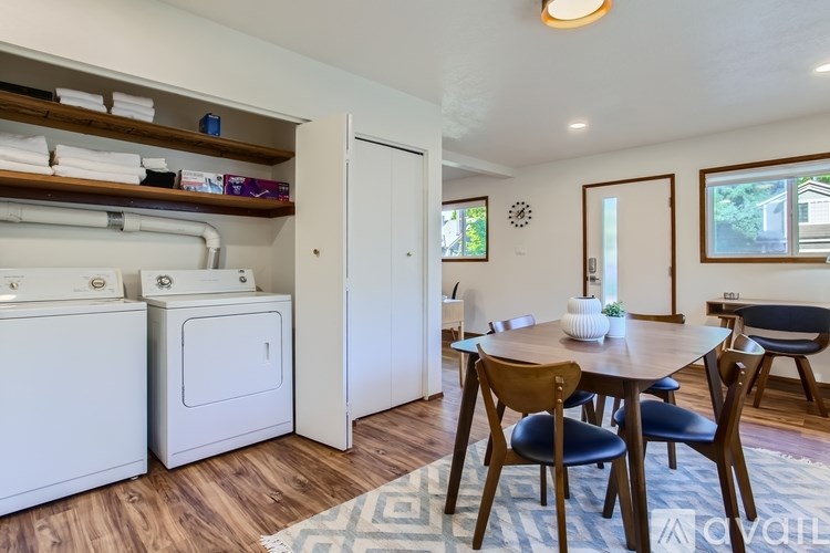A kitchen with a washing machine and dryer in the laundry area.