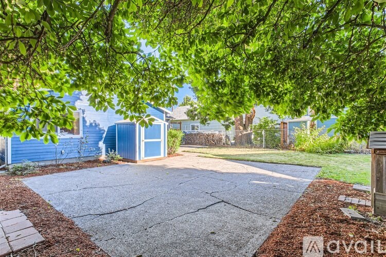 A driveway leads to a house with a blue exterior.