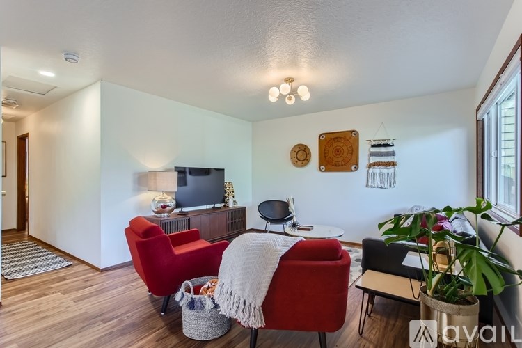 A living room with a red chair and a white blanket on it.