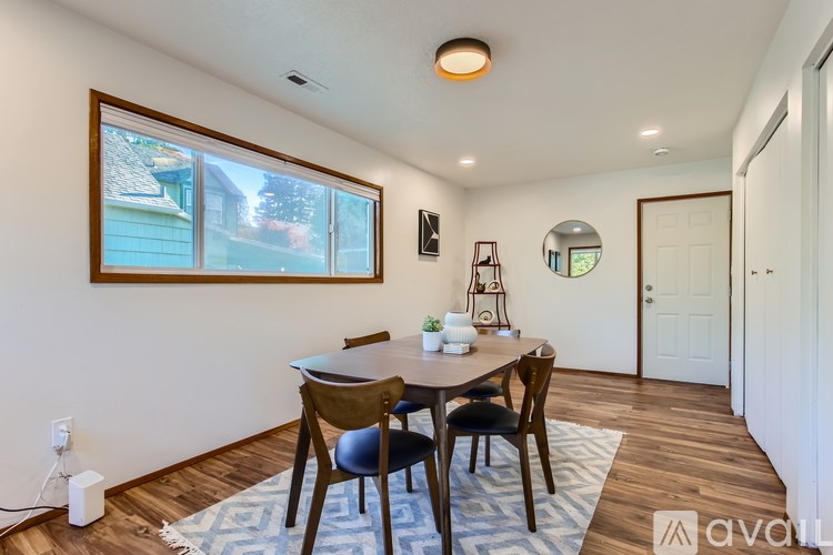 A dining room with a wooden table and chairs.