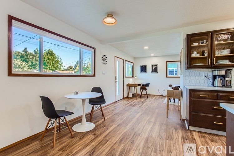 A kitchen with a table and chairs in front of a window.