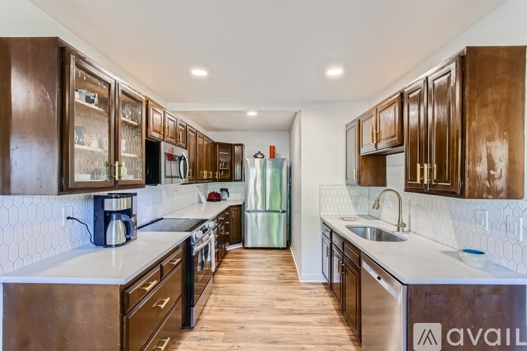 A kitchen with dark wood cabinets and stainless steel appliances.