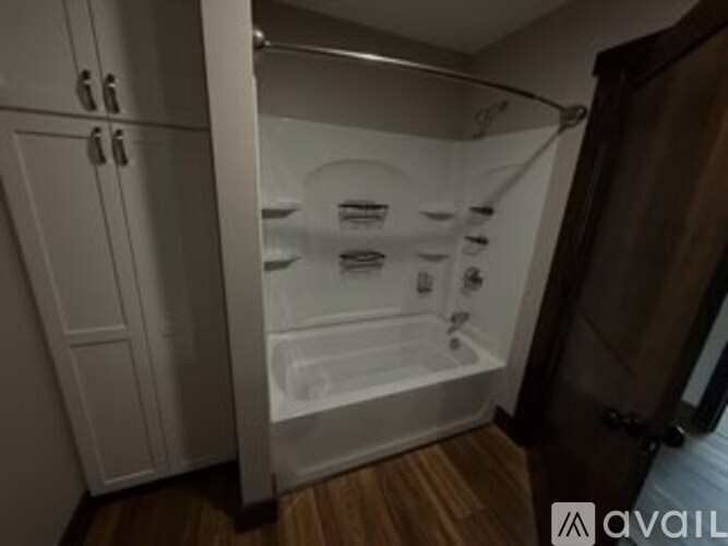 A white bathtub with a shower head and faucet.