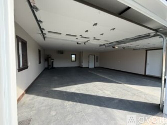 A room with a white ceiling and walls, and a concrete floor.