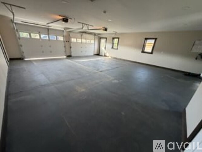 A spacious empty room with a concrete floor and white walls.