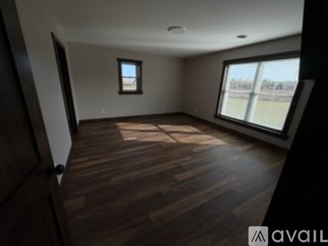 A room with wooden flooring and a window.