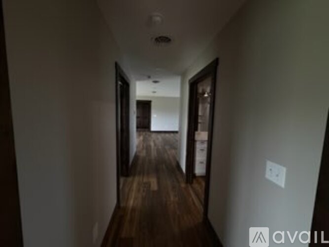 A hallway with wood floors and white walls.