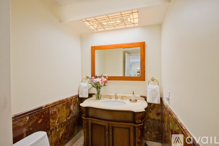 A bathroom with a brown wooden vanity and a white toilet.