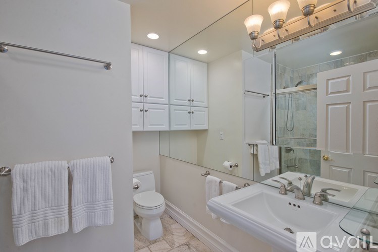 A bathroom with a white toilet, sink, and towel rack.