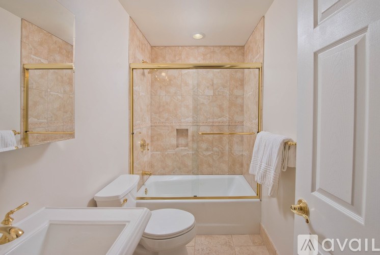 A bathroom with a tub, toilet, and sink.