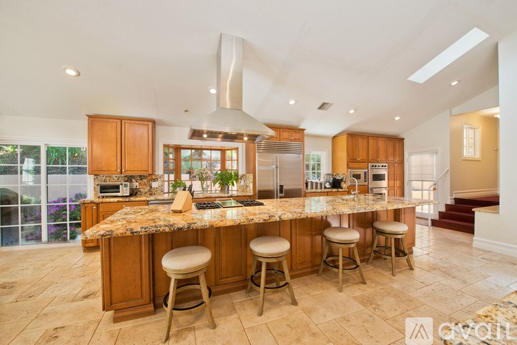 A kitchen with a marble countertop and wooden cabinets.